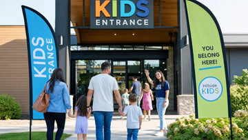 Families arriving at a modern church with Kids Ministry feather flags