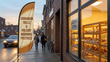 Artisan corner bakery with 13ft Cinnamon Rolls & Holiday Morning Pastries feather flag catching commuter headlights