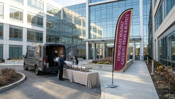Commercial feather flag promoting Corporate Holiday Catering Trays and Buffets outside busy restaurant kitchen