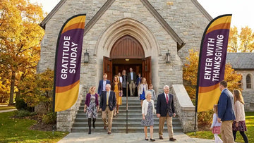 Grand church sanctuary portico flanked by Gratitude Sunday worship feather banners in royal purple and gold
