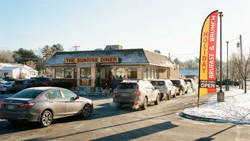 Bustling roadside diner drive-thru with Holiday Breakfast & Brunch Drive-Thru Open 13ft feather flag