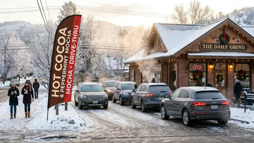 Artisan coffee shop drive-thru on a frosty winter morning with a commercial 13ft Hot Cocoa & Peppermint Mocha feather flag