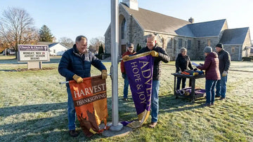 Church volunteer seamlessly swapping Thanksgiving feather banner for Advent banner on universal pole kit