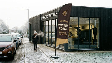 Modern independent espresso roastery with 13ft Artisanal Winter Roast Coffee & Espresso feather flag
