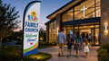 Family Church Experience feather flag at a modern church entrance at dusk
