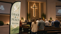 Case study 3: Grace and Peace church feather flag with dove design near a peaceful church garden entrance