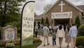 Grace and Peace church feather flag with dove design near a peaceful church garden entrance