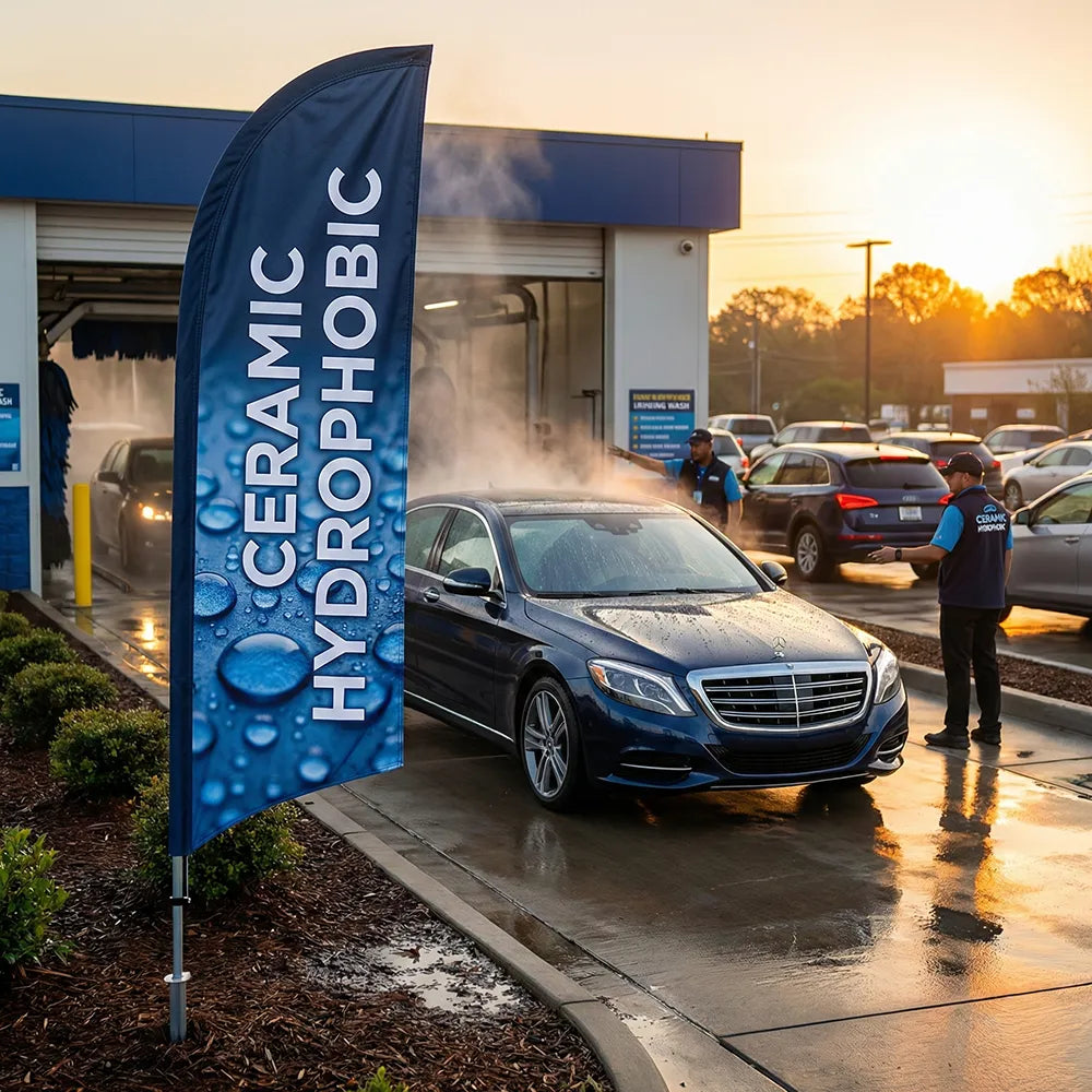 Ceramic Hydrophobic feather flag with water-bead graphics standing at the exit of a premium car wash facility.