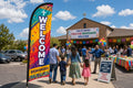 Hispanic / Bilingual Ministry church feather flag at parking lot entrance guiding first-time visitors