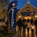 Navy and gold Christmas church feather flag with WELCOME text outside a decorated Advent church service