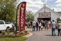 Rural / Country Church church feather flag at parking lot entrance guiding first-time visitors