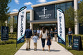 Two Modern Multi-Campus church feather flags flanking main entrance with greeters and families arriving