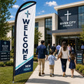 Modern navy and white church feather flag with WELCOME text outside a contemporary church campus
