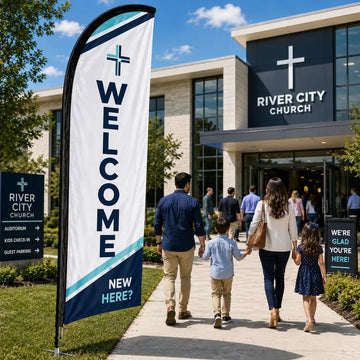 Modern navy and white church feather flag with WELCOME text outside a contemporary church campus