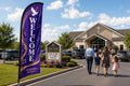 Praise and worship church feather flag placed roadside 500ft before entrance visible to Sunday traffic