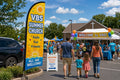 VBS / Summer church feather flag at parking lot entrance guiding first-time visitors