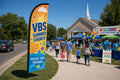 Church feather flag VBS / Summer placed roadside 500ft before entrance visible to Sunday traffic