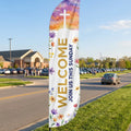 Church Welcome feather flag planted on grass verge 500ft before church entrance — roadside visibility for Sunday morning drivers at 45mph