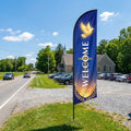 Welcome church feather flag at roadside driveway entrance of rural church visible to passing traffic