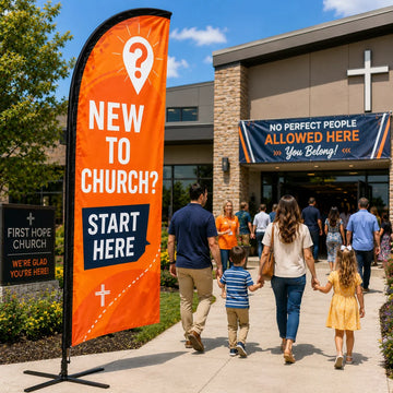 Orange New To Church guest services feather flag outside a church welcome table and entrance