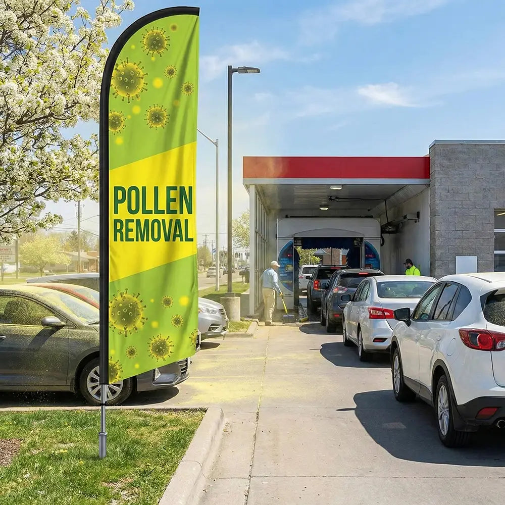 Bright green and yellow Pollen Removal feather flag standing in front of a car wash during peak spring pollen season.