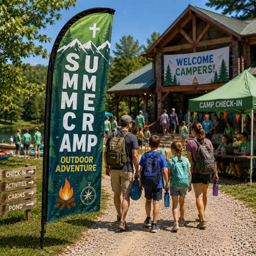 Summer Camp Outdoor Adventure church feather flag on a church lawn with campers, volunteers, tents, and check-in activity