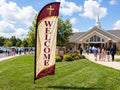 Welcome feather flag for church placed roadside 500ft before entrance visible to passing traffic on Sunday morning